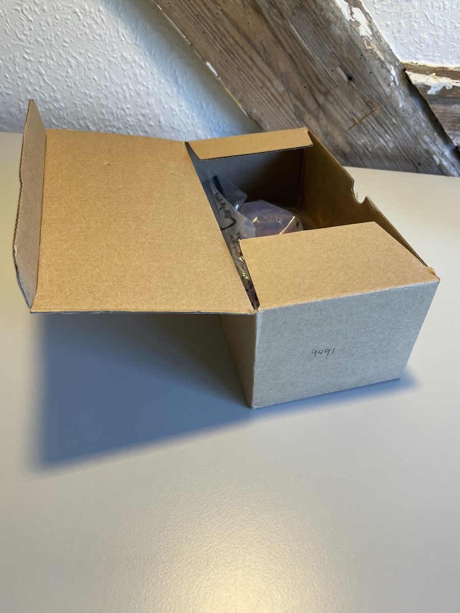 An open cardboard box marked 9491, with a bag of parts inside